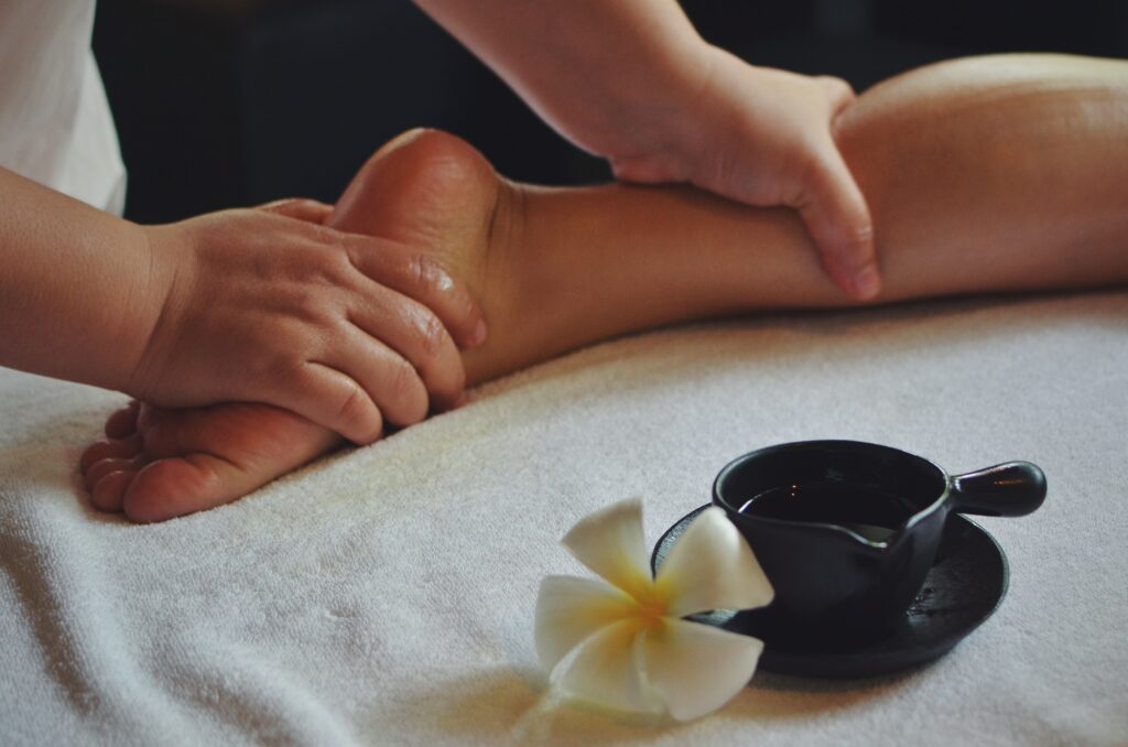 The therapist doing foot massage in spa treatment room